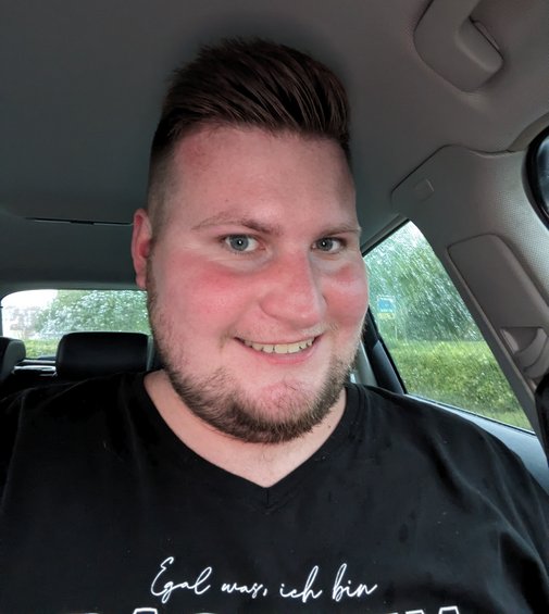 Adrian Kaps in seinem Auto, er lächelt in die Kamera