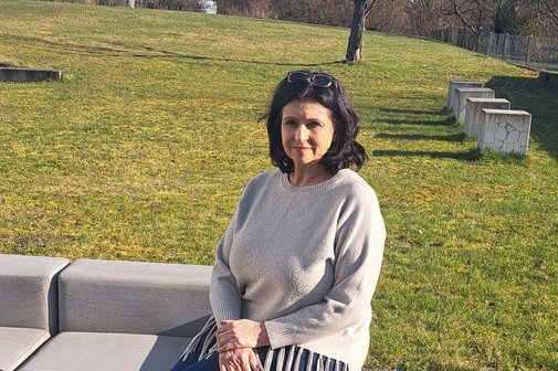 Diana Müll sitzt im Freien auf einer Bank.