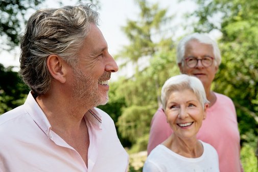 Senioren lachend Zwei ältere Männer und eine ältere Frau sind gut gelaunt, lachen. Sie sind draußen im Grünen.