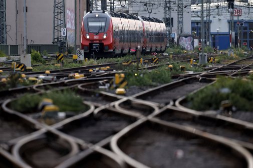 Eine Regionalbahn f&auml;hrt am K&ouml;lner Hauptbahnhof, man sieht zahlreiche Gleise und Weichen der Strecke.