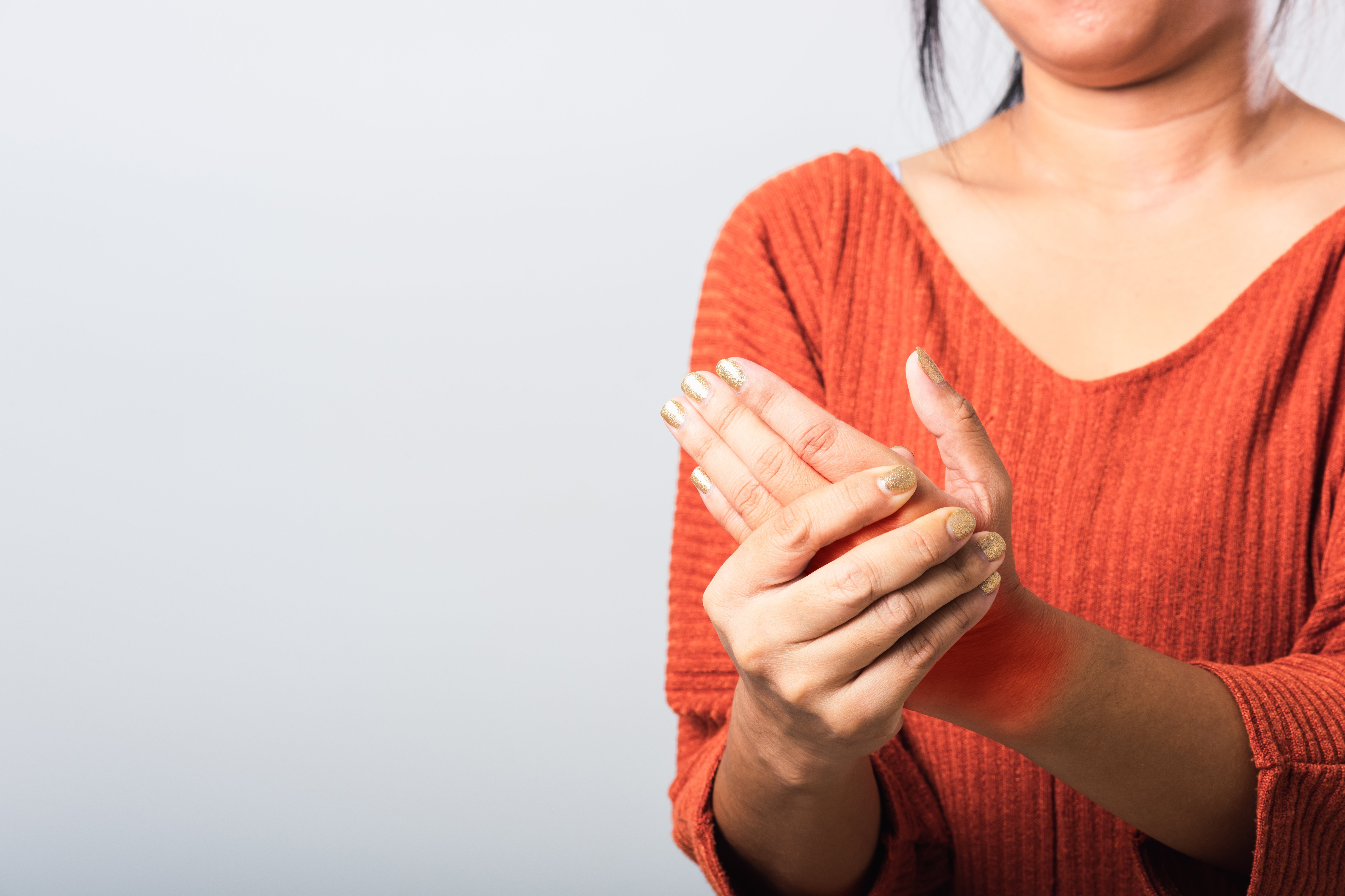 Frau mit Rheuma Eine Frau Hält sich ihre offenbar schmerzende Hand.