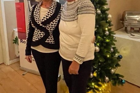2 Damen aus dem Vorstand vor dem dekorierten Weihnachtsbaum und dem VdK-L&uuml;beck-Aufsteller