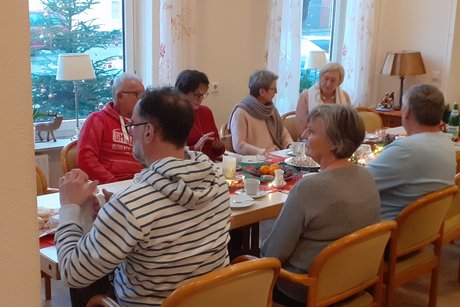 mehrere Personen des Vereines sitzen an einer Kaffeetafel zu einem weihnachtlichen Beisammensein