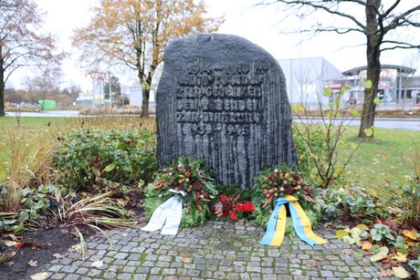 Ein Ehrenmal in Form eines Gedenksteines mit einem Kranz zum Gedenken an die Opfer von Kriegen
