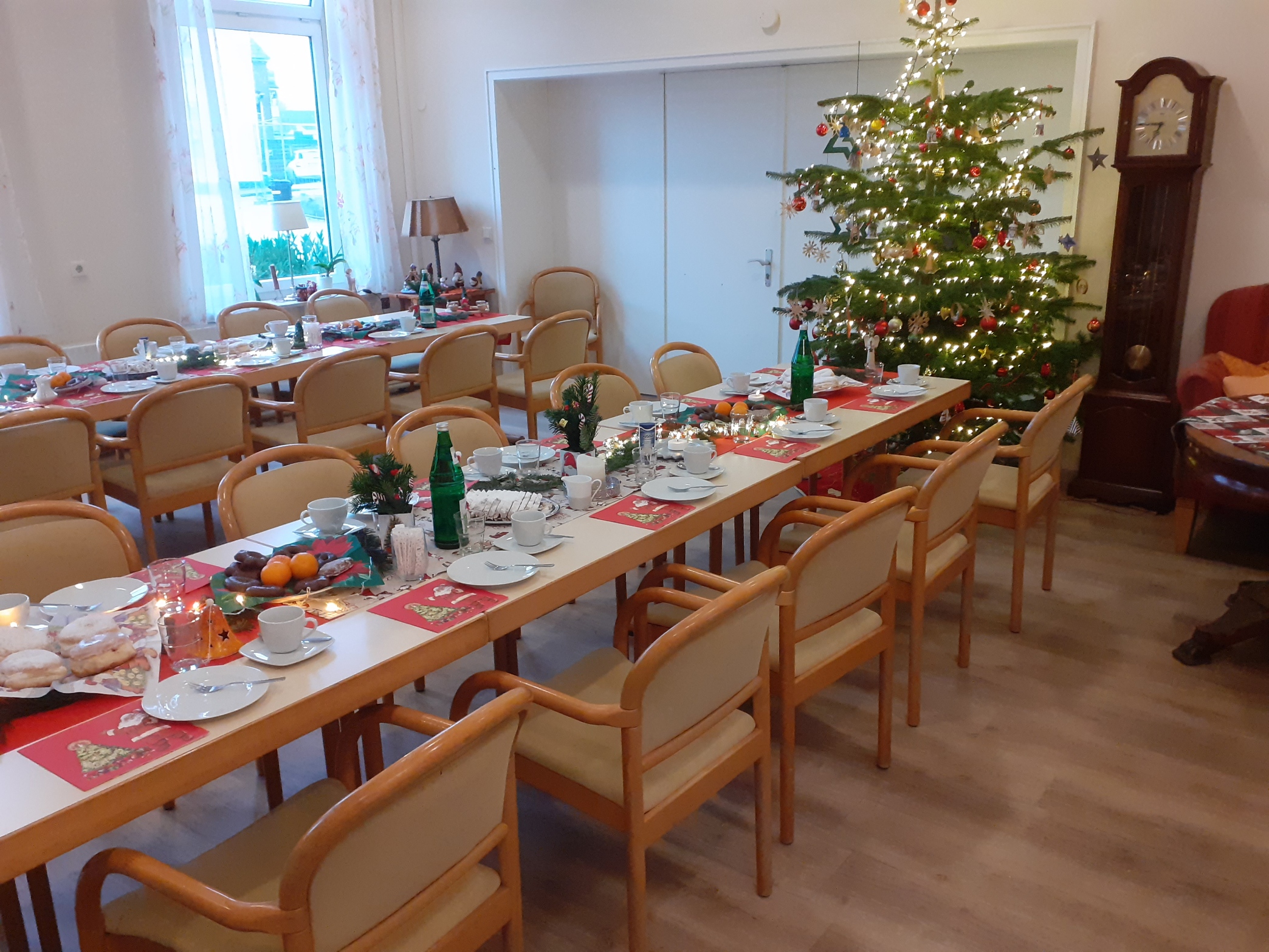 gedeckte Tische in weihnachtlichem Ambiente, im Hintergrund ein Weihnachtsbaum